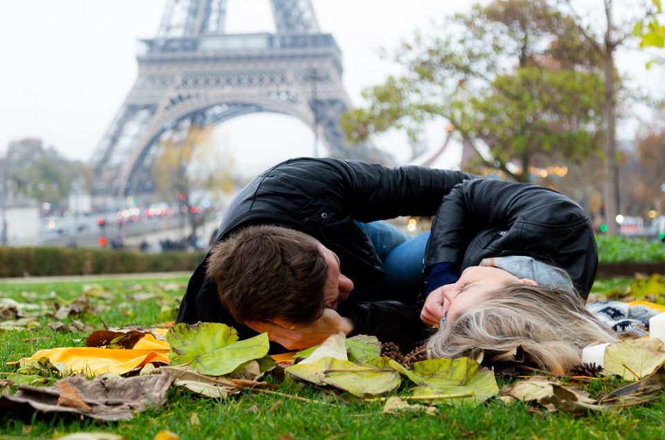 Ensaio na Torre Eiffel por fotografo brasileiro em Paris que registra casal deitado na grama no Trocadéro durante outono